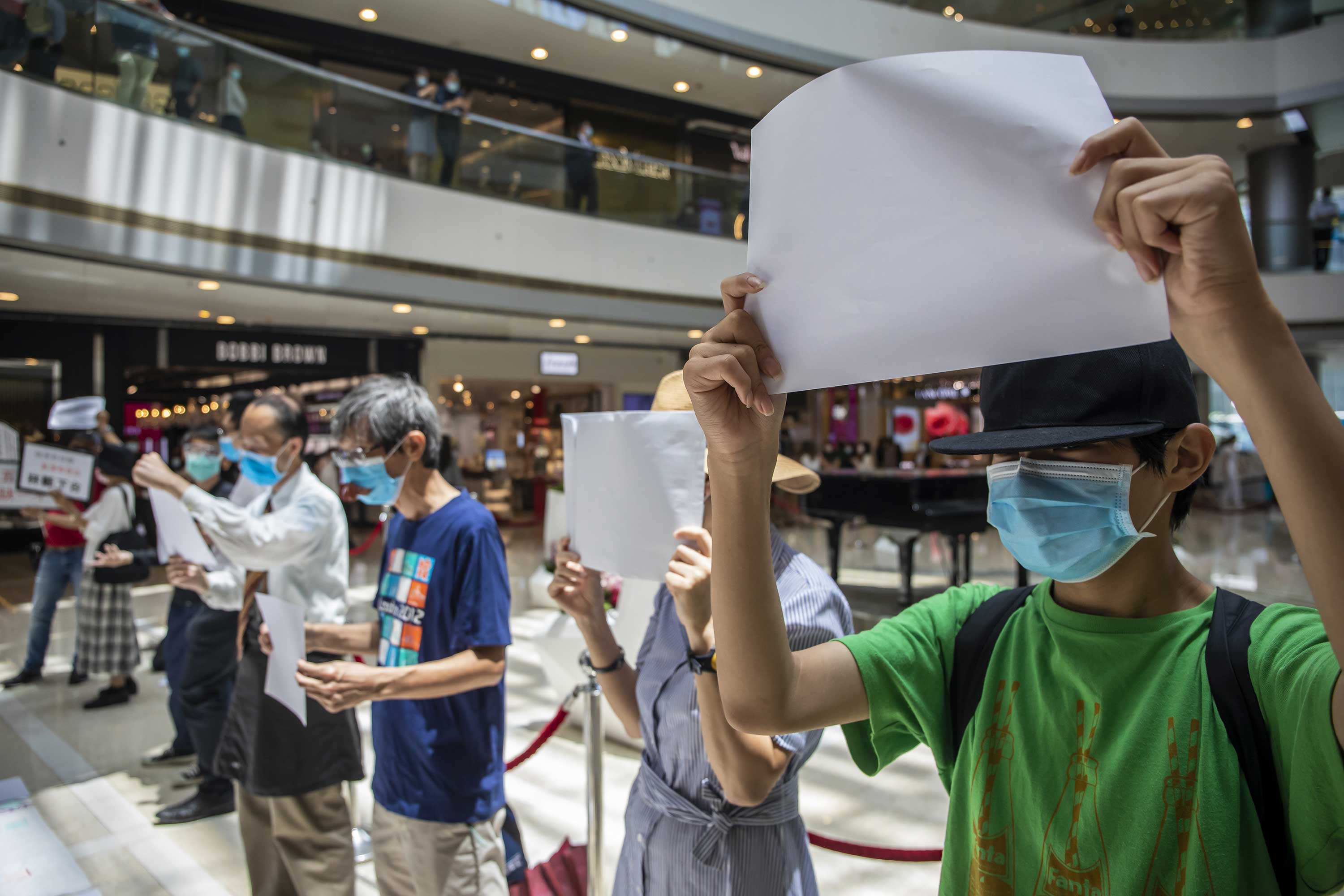 Hongkong Proteste: Protestierende halten leere weiße Schilder in einem Einkaufszentrum hoch.
